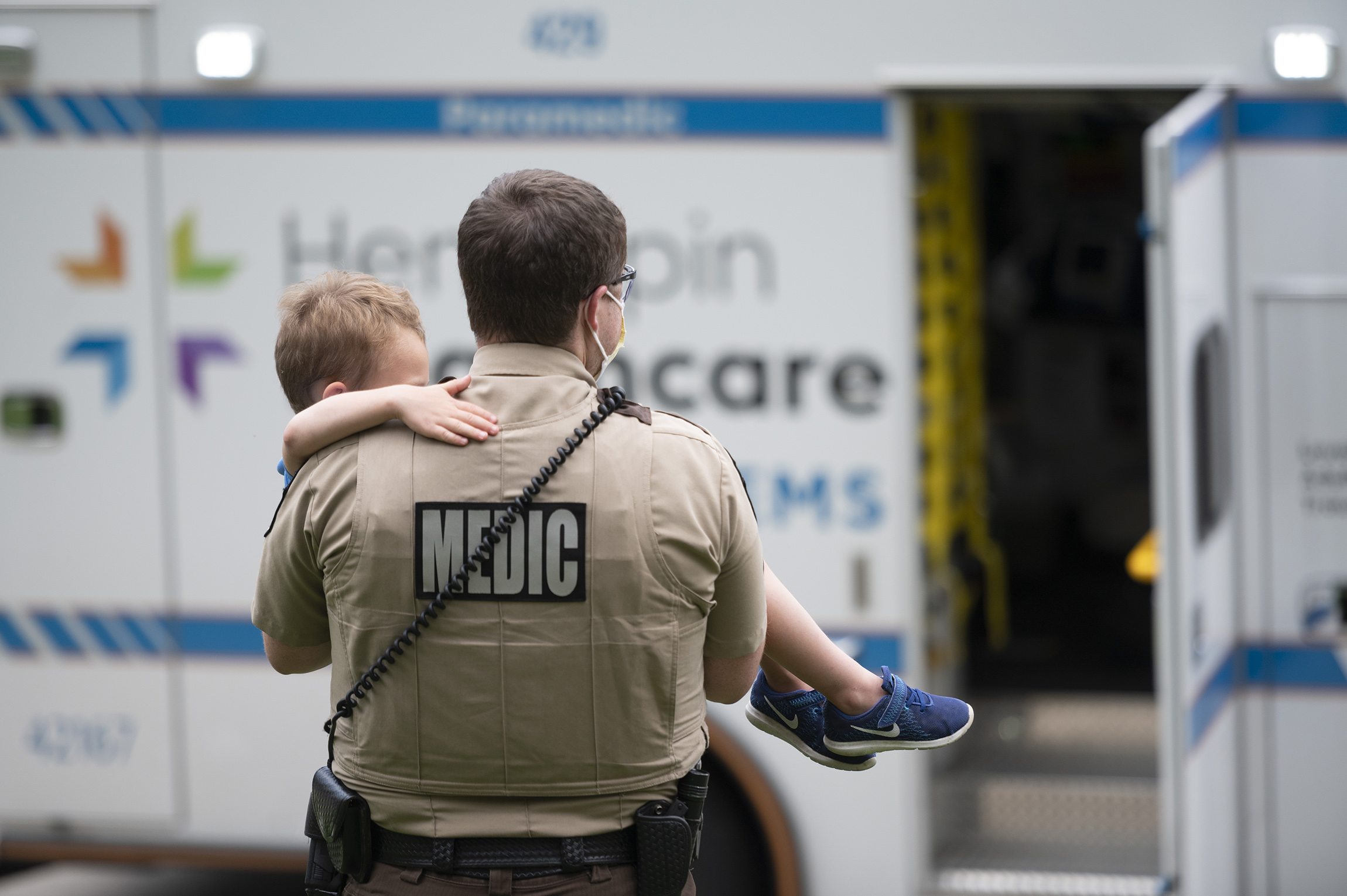 paramedic carrying child to ambulance