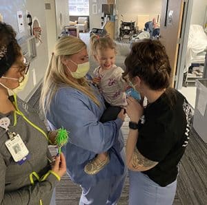 kelsie being held by nurses in hyperbaric center, dog attack, girl suffers ear amputation, successful hyperbaric treatment, kenzie riemenschneider, facial lacerations from dog attack